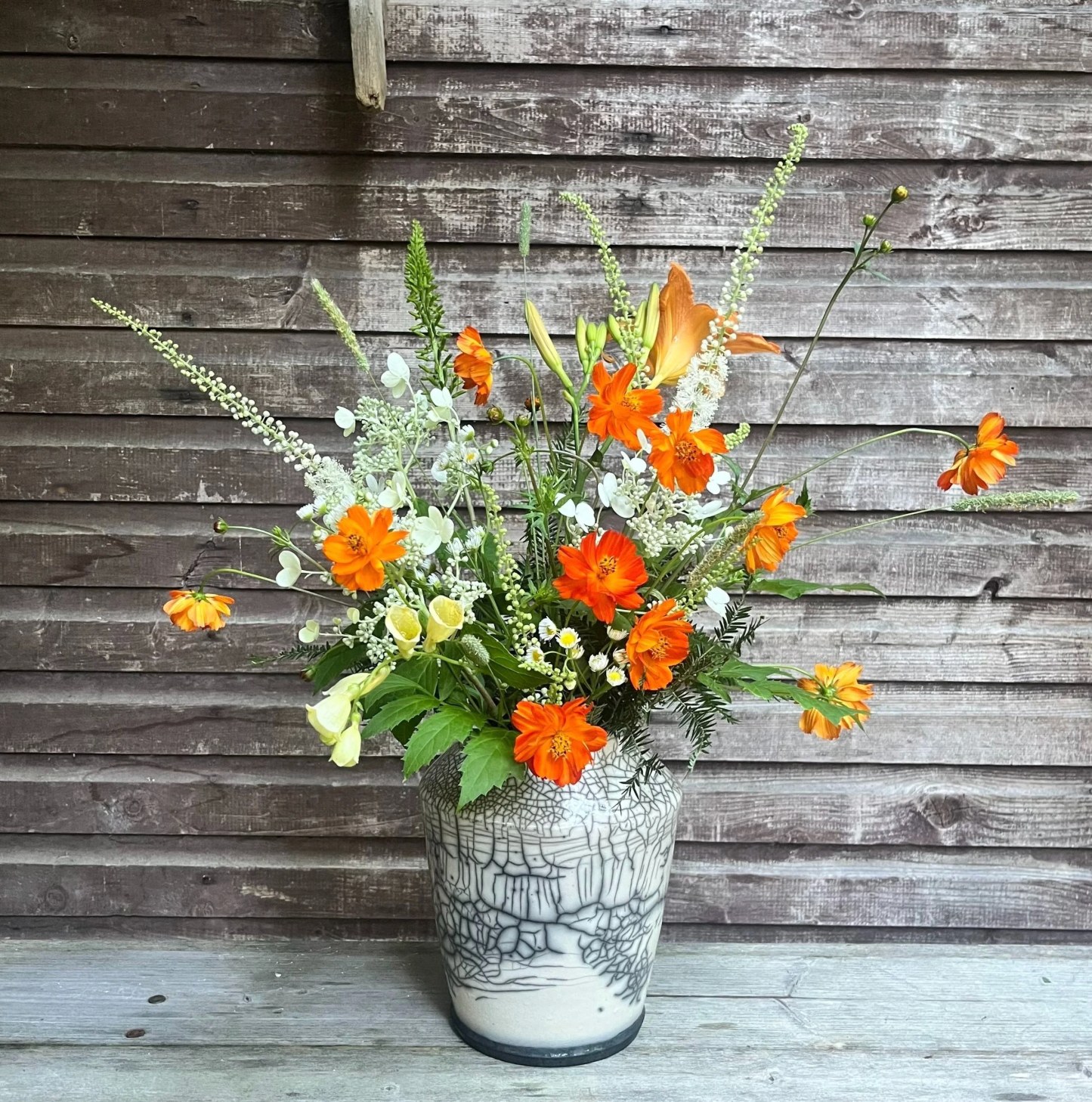 Kosmo Farm bouquet of orange cosmos, daylilies, and white flowers in a handmade raku ceramic vase, Richmond Vermont