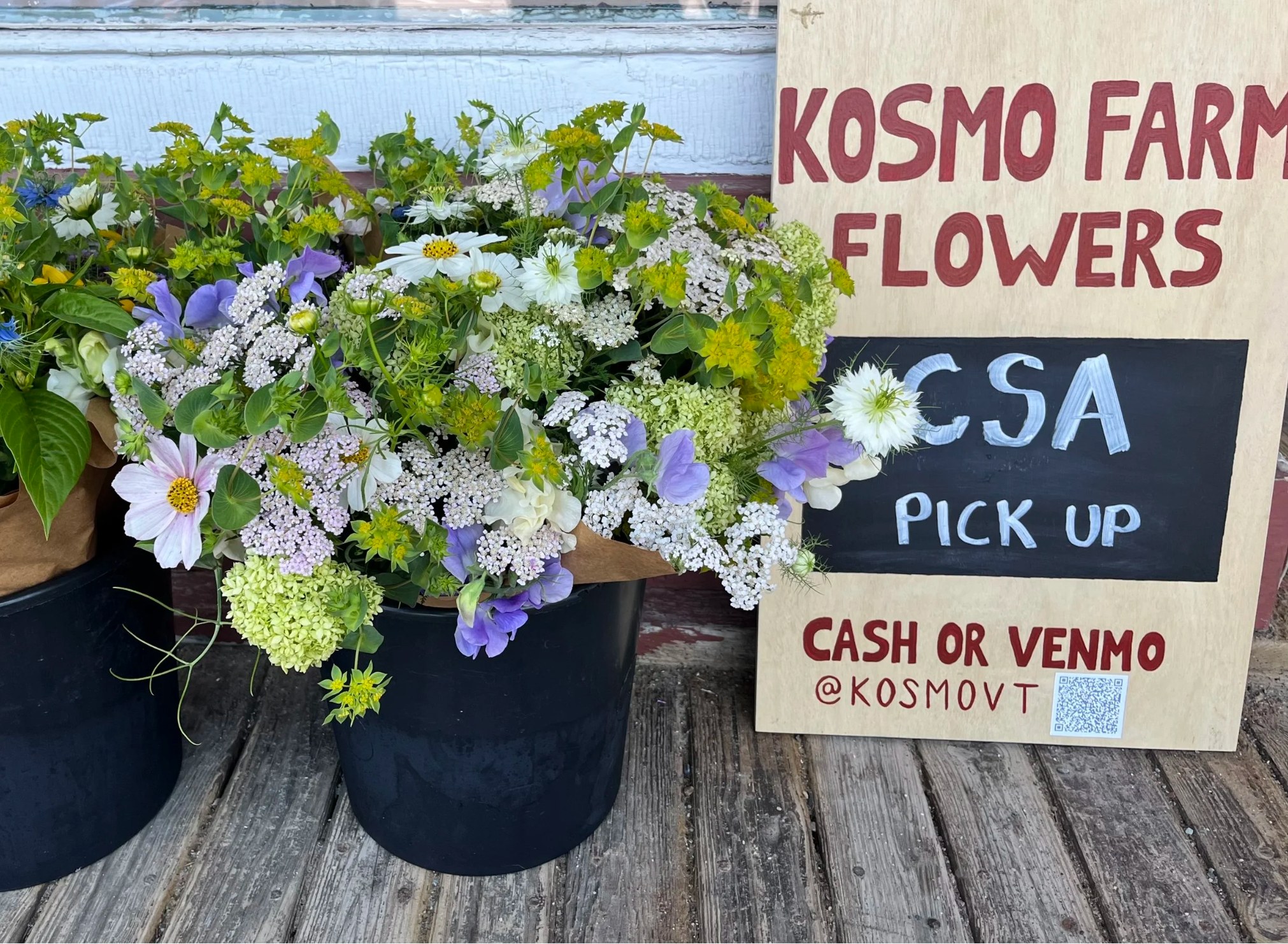 Kosmo Farm Flowers CSA pick-up: buckets of fresh bouquets beside a hand-painted sign reading cash or Venmo @kosmovt